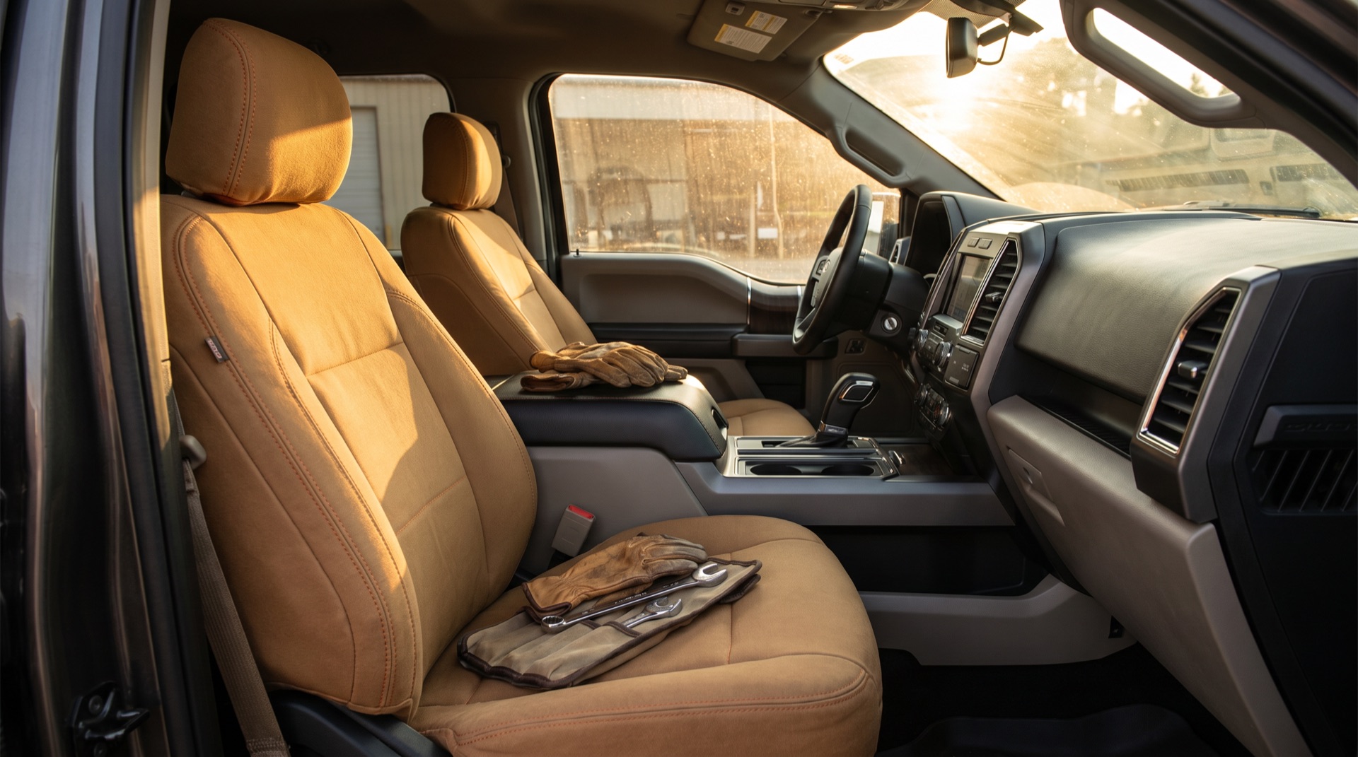 Truck cab interior fitted with duck-canvas tan Supreme seat covers, work gloves and a wrench roll resting on the passenger seat